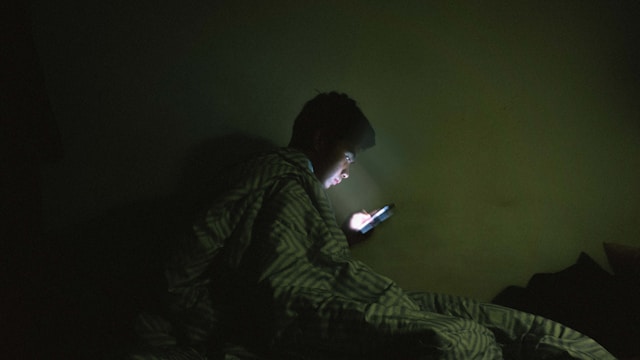 ser humano no celular a cama