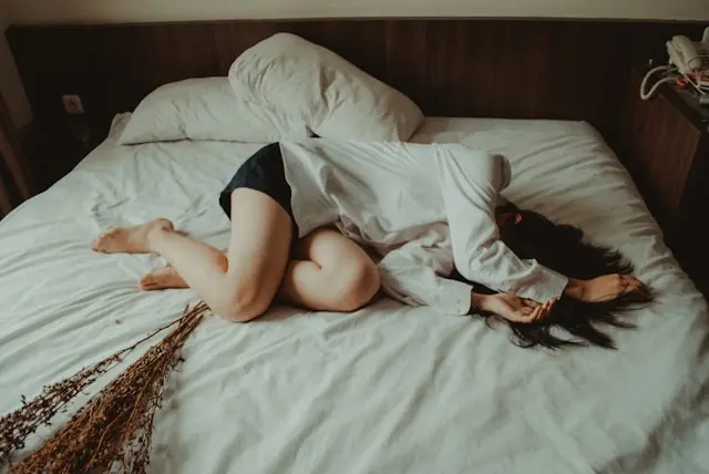 mulher deitada na cama, com cólicas