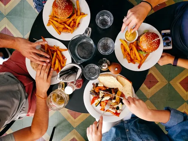 mesa de fastfood com 3 pessoas sentadas
